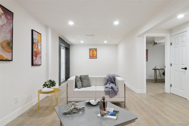 living room featuring baseboards, recessed lighting, and light wood-type flooring