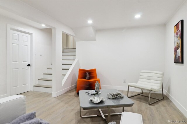 sitting room featuring stairs, baseboards, recessed lighting, and wood finished floors