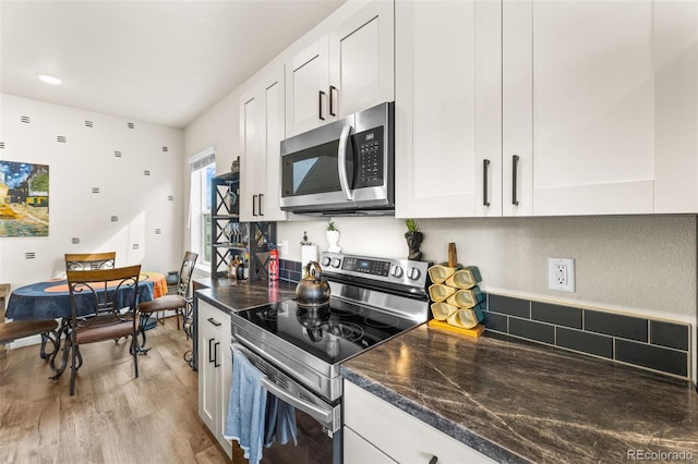 kitchen featuring white cabinetry, light wood finished floors, and stainless steel appliances