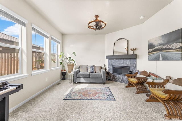 living room featuring visible vents, a notable chandelier, a high end fireplace, carpet, and baseboards