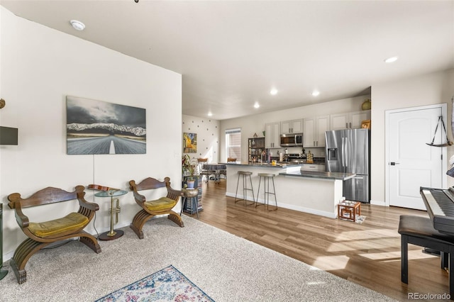 living room featuring recessed lighting, baseboards, and wood finished floors