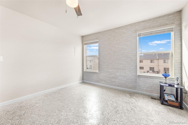 unfurnished room featuring speckled floor, baseboards, and ceiling fan