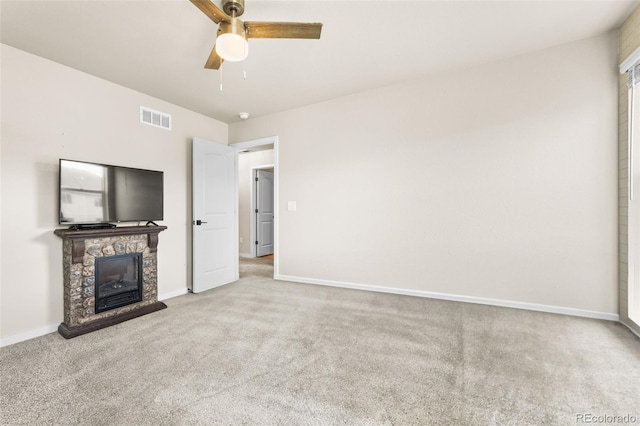 unfurnished living room with visible vents, carpet, a fireplace, baseboards, and ceiling fan