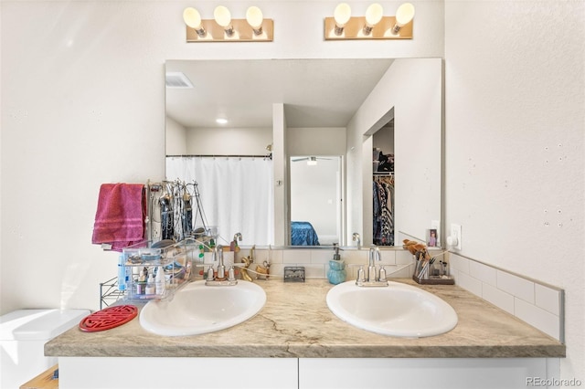 bathroom with a sink, visible vents, a shower with curtain, and double vanity