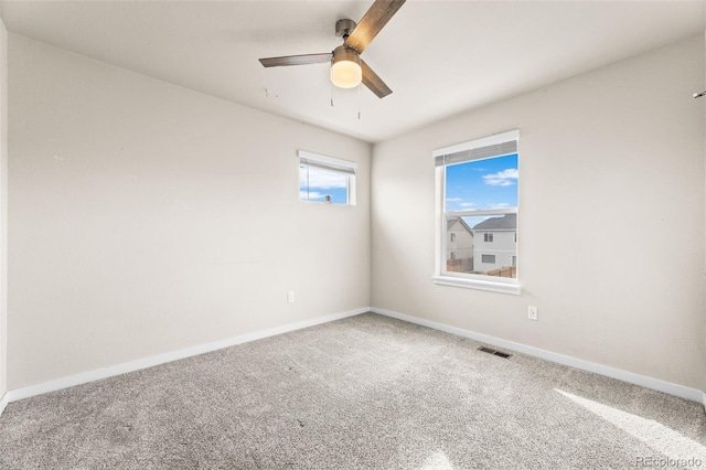 spare room featuring a ceiling fan, carpet flooring, baseboards, and visible vents