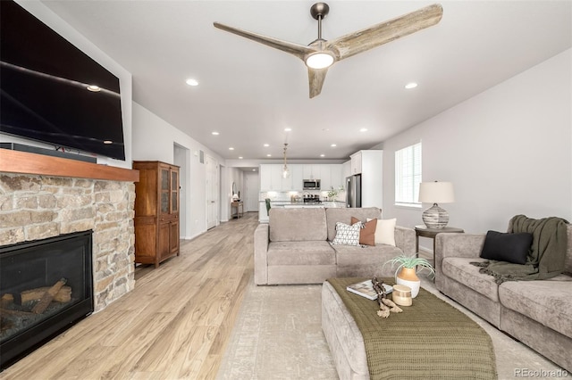 7202 S Valleyhead Ct, Aurora, CO 80016 - living area featuring light wood-style flooring, a stone fireplace, recessed lighting, and ceiling fan
