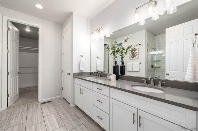 7202 S Valleyhead Ct, Aurora, CO 80016 - bathroom featuring tiled shower, double vanity, recessed lighting, baseboards, and a spacious closet