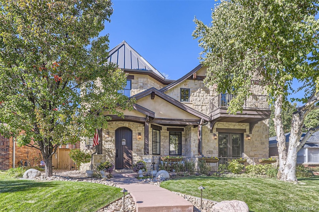 view of front of property with a balcony and a front yard