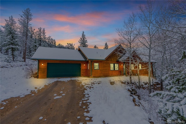 chalet / cabin with an attached garage and dirt driveway