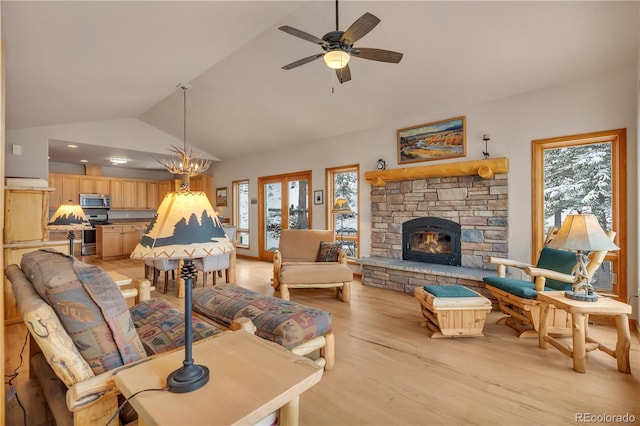 living room featuring a stone fireplace, a ceiling fan, light wood-style flooring, and lofted ceiling