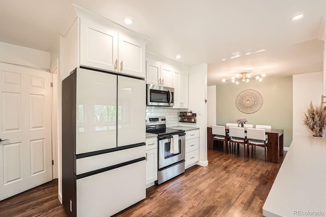 1465 S Urban Way, Lakewood, CO 80228 - kitchen featuring white cabinets, dark wood-style flooring, a notable chandelier, stainless steel appliances, and tasteful backsplash