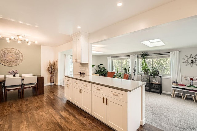 1465 S Urban Way, Lakewood, CO 80228 - kitchen with a skylight, baseboards, white cabinets, a notable chandelier, and recessed lighting
