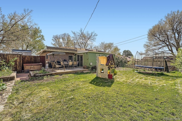 1465 S Urban Way, Lakewood, CO 80228 - view of yard featuring a fenced backyard, a trampoline, a hot tub, and a deck