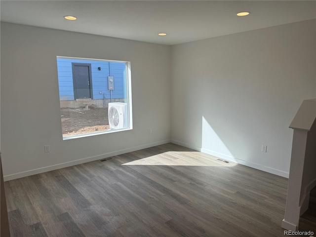 empty room with recessed lighting, wood finished floors, visible vents, and baseboards