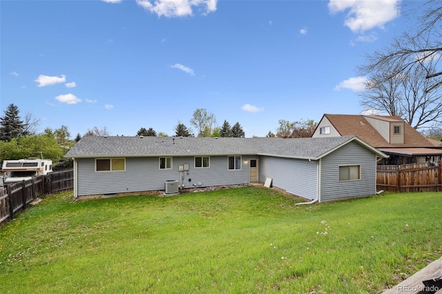 back of property with a fenced backyard, central air condition unit, and a yard