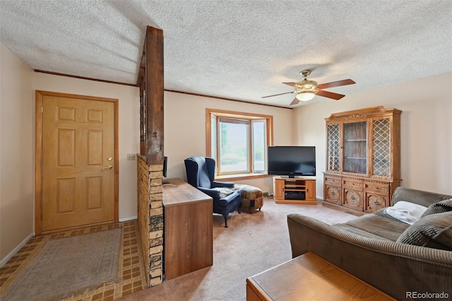 living area featuring baseboards, a ceiling fan, and a textured ceiling