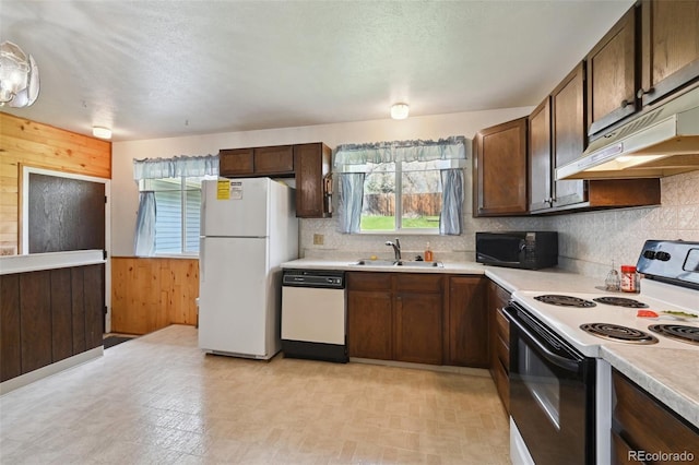 kitchen featuring a sink, light countertops, plenty of natural light, and white appliances