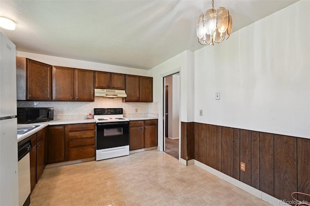 kitchen featuring black microwave, light countertops, electric stove, under cabinet range hood, and dishwashing machine