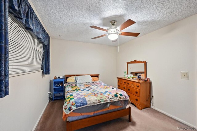 carpeted bedroom with baseboards, a ceiling fan, and a textured ceiling