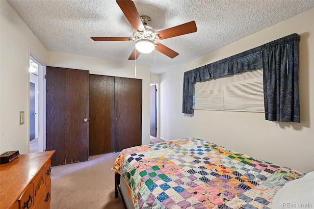 bedroom featuring a ceiling fan, a textured ceiling, light colored carpet, and a closet