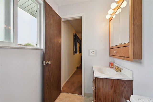 bathroom with vanity, baseboards, and toilet