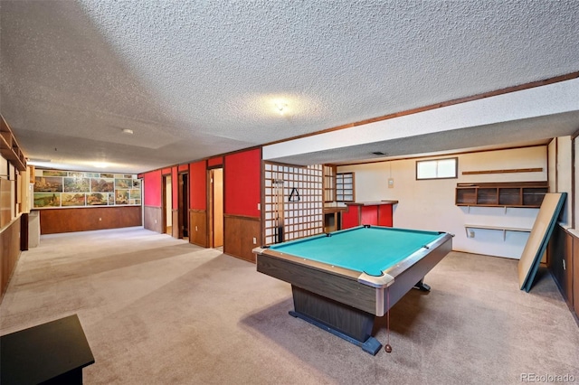 rec room featuring a textured ceiling, pool table, wainscoting, wooden walls, and carpet flooring
