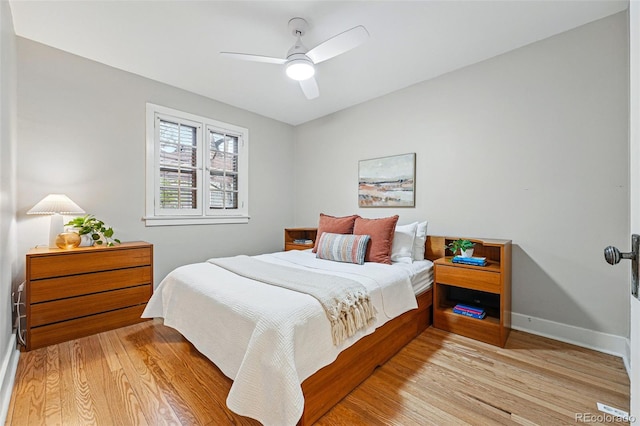 bedroom featuring baseboards, light wood finished floors, and ceiling fan