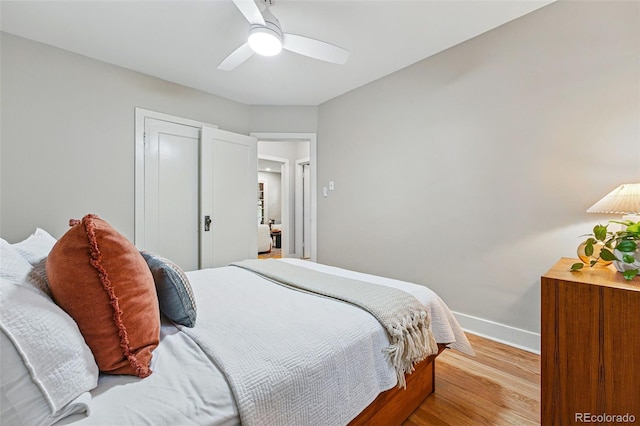 bedroom with a ceiling fan, baseboards, light wood-style flooring, and a closet
