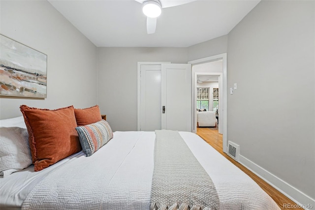 bedroom with visible vents, a ceiling fan, light wood finished floors, and baseboards