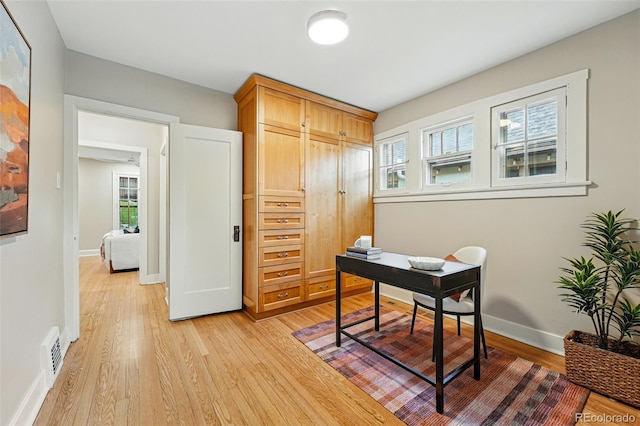 office area featuring visible vents, light wood-style flooring, and baseboards