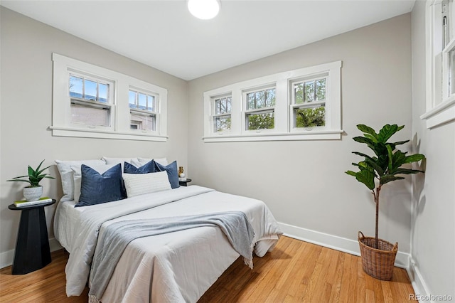 bedroom with baseboards and wood finished floors