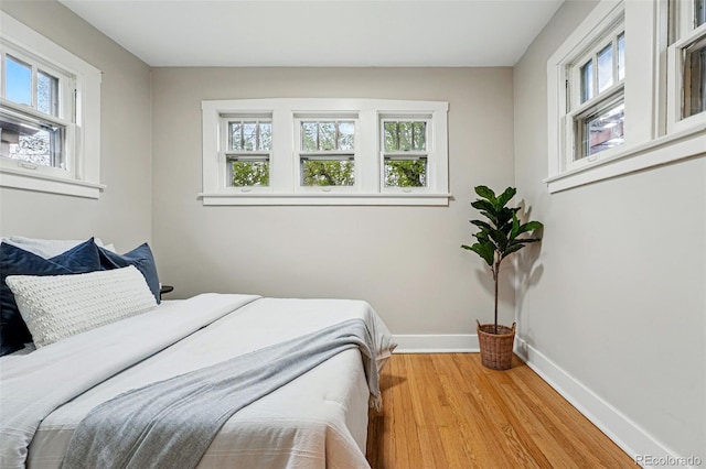 bedroom with baseboards and wood finished floors