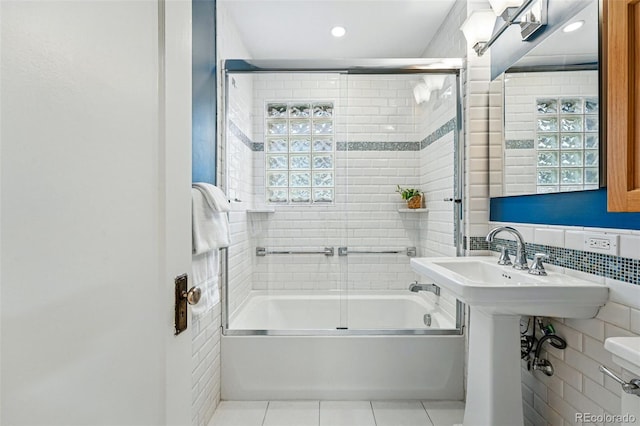 full bath featuring recessed lighting, combined bath / shower with glass door, tile patterned floors, and tile walls