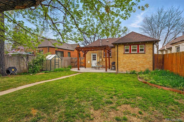 rear view of property featuring a pergola, a fenced backyard, a greenhouse, brick siding, and an outbuilding