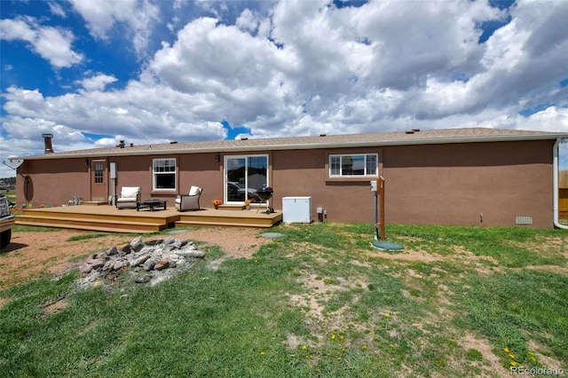 back of property with a lawn and a deck