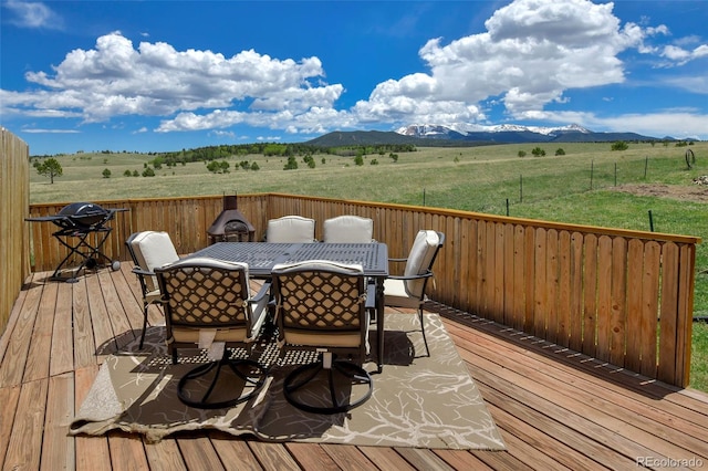 wooden terrace featuring a rural view and a mountain view