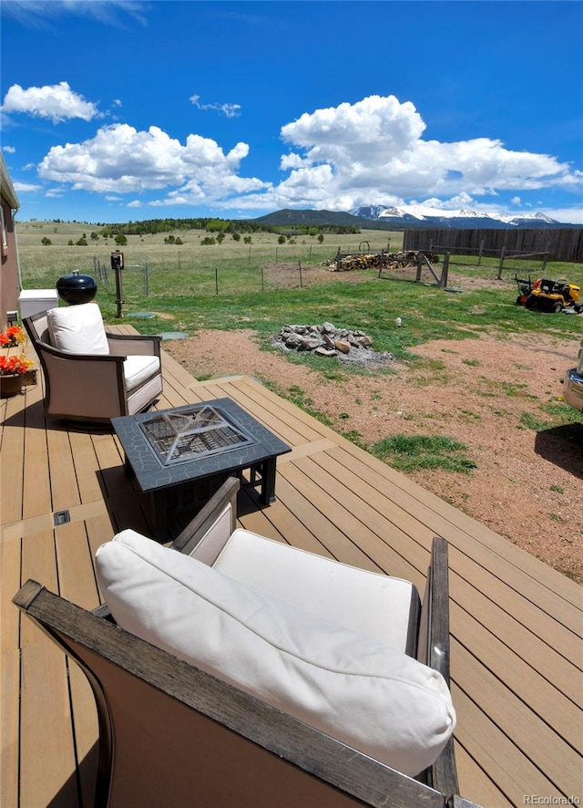 wooden deck with a fire pit and a rural view