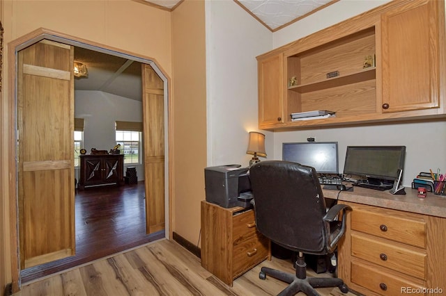 office space featuring crown molding, vaulted ceiling, and light hardwood / wood-style flooring