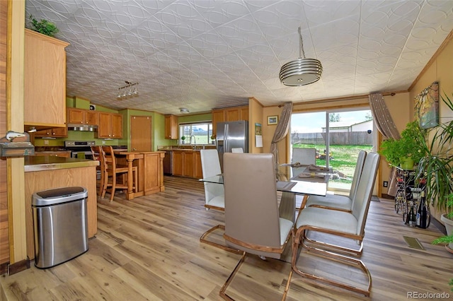 dining space featuring lofted ceiling and light hardwood / wood-style flooring