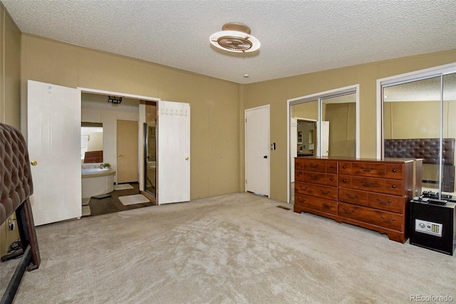 bedroom featuring two closets, carpet flooring, a fireplace, and a textured ceiling