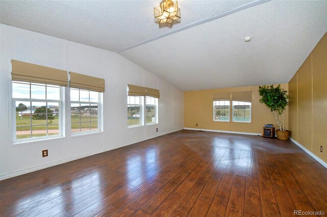 unfurnished living room with a textured ceiling, lofted ceiling, and dark hardwood / wood-style floors