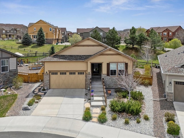 craftsman house with a residential view, fence, stone siding, a garage, and driveway