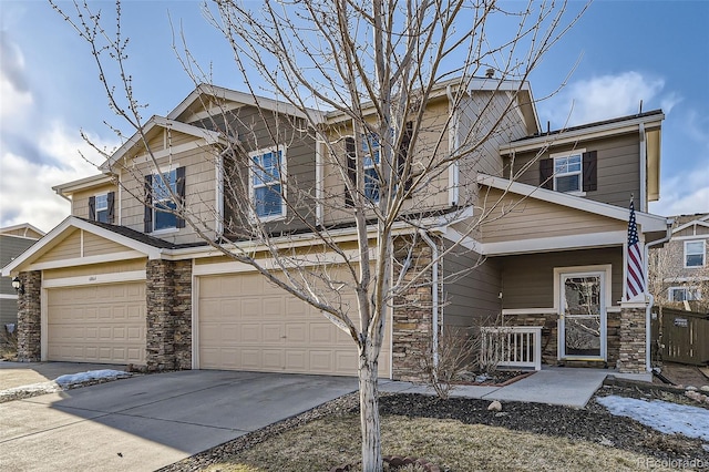 craftsman-style home featuring concrete driveway, a garage, and stone siding