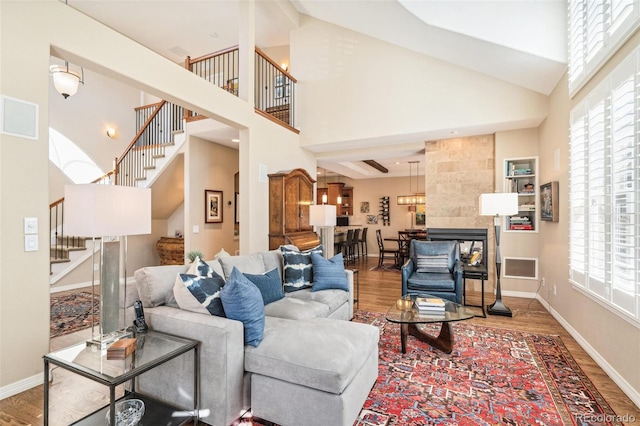 living area with stairs, baseboards, and wood finished floors