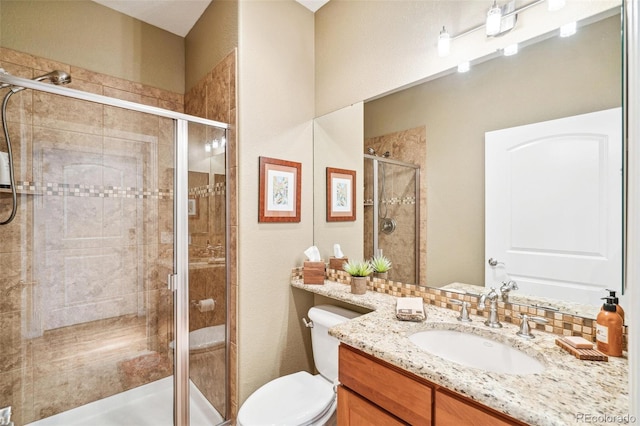 full bathroom featuring toilet, a shower stall, and vanity