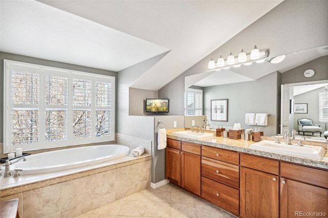 bathroom with vaulted ceiling, a garden tub, a sink, and tile patterned floors