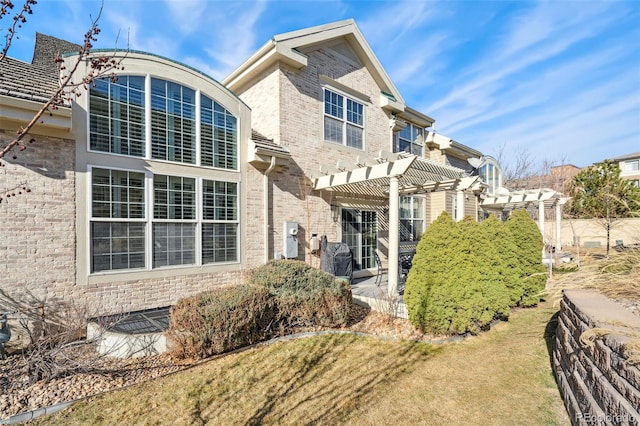 rear view of house with a patio, a pergola, and brick siding