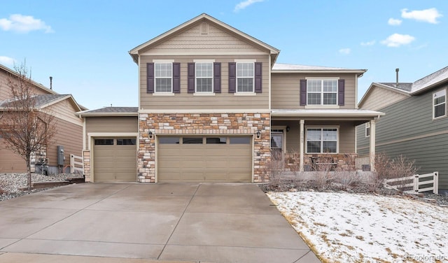 view of front of house with stone siding, an attached garage, a porch, and driveway