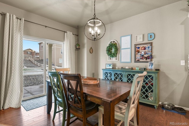 dining area with a notable chandelier, baseboards, and wood finished floors