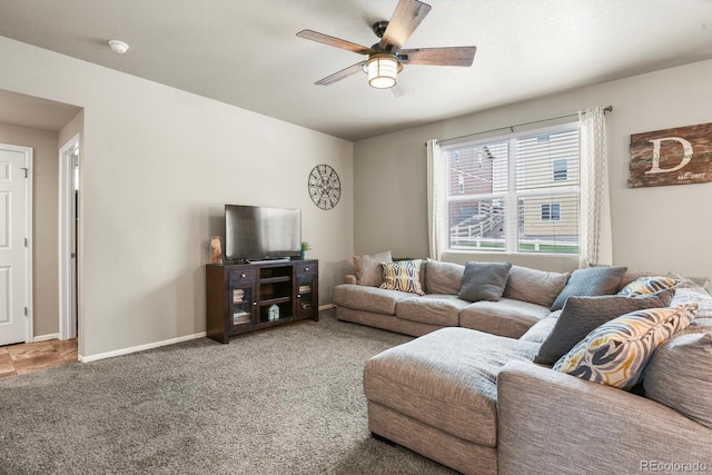 carpeted living area featuring baseboards and ceiling fan